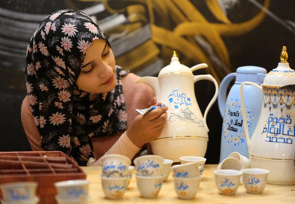 May 8, 2021, Maghazi, Gaza Strip, Palestinian Territory: Palestinian artist, Abeer Al-Tallaa, 23, paints on the pots and cups of coffee the congratulatory phrases for Eid Al Fitr, at Maghazi refugee camp in the center of the Gaza Strip, on May 8, 2021. People flock markets and shopping malls as they shop for food and new clothings in preparation for Eid al Fitr holiday that marks the end of Ramadan, the holiest month in Islamic calendar Maghazi Palestinian Territory - ZUMAap3_ 20210508_zaf_ap3_037 Copyright: xAshrafxAmrax