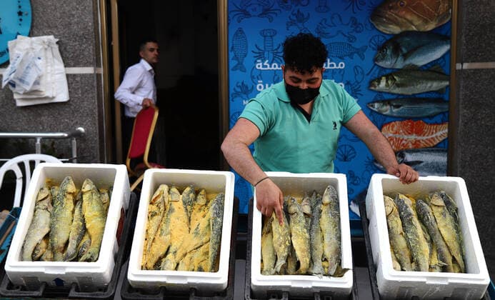 May 8, 2021, Gaza city, Gaza Strip, Palestinian Territory: Palestinian men wearing masks, prepare salted fish to be sold in markets ahead Eid al Fitr holiday in Gaza City, on May 8, 2021. Salted fish, such as kippered herring or dried and salted cod, is fish cured with dry salt and thus preserved for later eating. Drying or salting, either with dry salt or with brine, was the only widely available method of preserving fish until the 19th century Gaza city Palestinian Territory - ZUMAap3_ 20210508_zaf_ap3_079 Copyright: xMahmoudxAjjourx