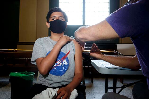 May 17, 2021, Winnipeg, mb, Canada: Dr. Barry Lavallee, CEO, Keewatinowi Inniniw Minoayawin, administers the Pfizer-BioNTech vaccine to Sam Hallett, 12, at the Aboriginal Health and Wellness Centre in Winnipeg, Monday, May 17, 2021. Winnipeg Canada - ZUMAc35_ 20210517_zaf_c35_013 Copyright: xMikexDealx