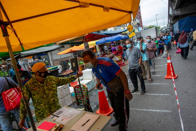 (210529) -- KUALA LUMPUR, May 29, 2021 -- People wearing face masks line up to enter a market before a lockdown in Kuala Lumpur, Malaysia, May 29, 2021. Malaysia reported jumps in the highest daily record of new COVID-19 cases and deaths on Saturday, after the government announced a total lockdown to contain the outbreak. A new daily high of 9,020 infections were reported, an increase from the previous high of 8,290 cases just recorded a day ago, bringing the national total to 558,534, according to the health ministry. A recent spike of COVID-19 cases in Malaysia has forced the government to announce on Friday to impose a total lockdown from June 1 to 14, restricting all sectors except for essential services. (Photo by Chong Voon Chu