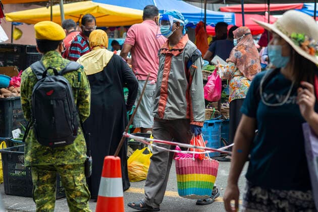 (210529) -- KUALA LUMPUR, May 29, 2021 -- People wearing face masks shop at a market before a lockdown in Kuala Lumpur, Malaysia, May 29, 2021. Malaysia reported jumps in the highest daily record of new COVID-19 cases and deaths on Saturday, after the government announced a total lockdown to contain the outbreak. A new daily high of 9,020 infections were reported, an increase from the previous high of 8,290 cases just recorded a day ago, bringing the national total to 558,534, according to the health ministry. A recent spike of COVID-19 cases in Malaysia has forced the government to announce on Friday to impose a total lockdown from June 1 to 14, restricting all sectors except for essential services. (Photo by Chong Voon Chung Xinhua