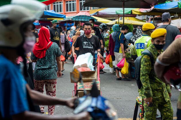 (210529) -- KUALA LUMPUR, May 29, 2021 -- People wearing face masks shop at a market before a lockdown in Kuala Lumpur, Malaysia, May 29, 2021. Malaysia reported jumps in the highest daily record of new COVID-19 cases and deaths on Saturday, after the government announced a total lockdown to contain the outbreak. A new daily high of 9,020 infections were reported, an increase from the previous high of 8,290 cases just recorded a day ago, bringing the national total to 558,534, according to the health ministry. A recent spike of COVID-19 cases in Malaysia has forced the government to announce on Friday to impose a total lockdown from June 1 to 14, restricting all sectors except for essential services. (Photo by Chong Voon Chung Xinhua