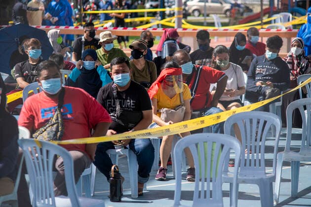 (210530) -- KLANG, May 30, 2021 -- People wearing face masks wait for COVID-19 swab tests in Klang, Selangor, Malaysia, May 30, 2021. Malaysia reported 6,999 new COVID-19 infections, the health ministry said Sunday, bringing the national total to 565,533. (Photo by Xinhua) MALAYSIA-COVID-19-CASES ChongxVoonxChung