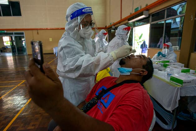 (210530) -- KLANG, May 30, 2021 -- A medical worker takes a swab sample from a man for COVID-19 test in Klang, Selangor, Malaysia, May 30, 2021. Malaysia reported 6,999 new COVID-19 infections, the health ministry said Sunday, bringing the national total to 565,533. (Photo by Xinhua) MALAYSIA-COVID-19-CASES ChongxVoonxChung
