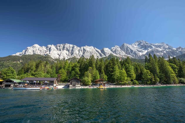 Grainau, Deutschland 14. Juni 2021: Der Eibsee in Bayern in der Gemeinde Grauinau, Nähe von Garmisch-Partenkirchen. Der See bietet Ruhe und eine Naturidylle auf 1000 m Höhe. Urlauber können in der Region Wandern, Radfahren und Wassersport betreiben. Hier ein Blick über den See aus die Zugspitze. Eibsee Bayern Copyright: xFotostandx xFritschx