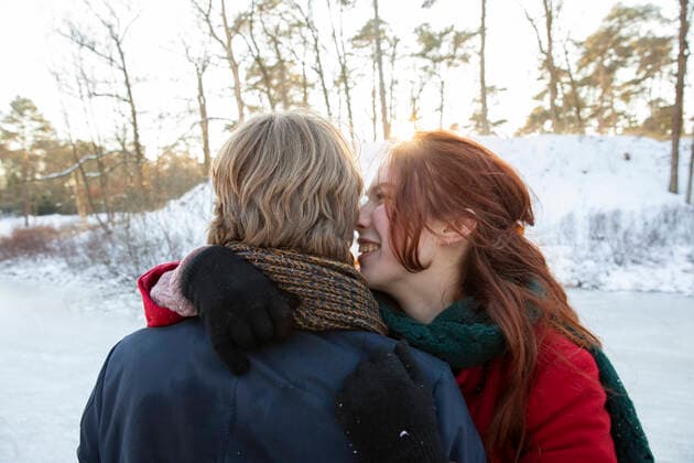 Smiling girlfriend embracing boyfriend during winter model released Symbolfoto FVDF00201