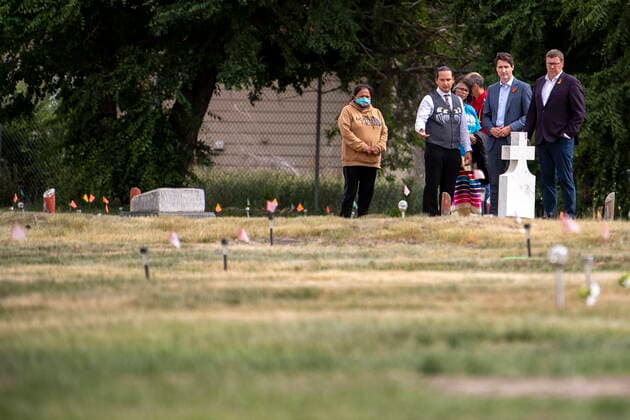July 6, 2021, Cowessess First Nation, SK, Canada: Chief Cadmus Delorme, left to right, Prime Minister Justin Trudeau, and Saskatchewan Premier Scott Moe walk though a field prior to a ceremony at the site of a former residential school where small flags which were placed, last month, in spots where ground-penetrating radar detected a potential 751 unmarked graves, in Cowessess First Nation, Sask., Tuesday, July 6, 2021. Cowessess First Nation Canada - ZUMAc35_ 20210706_zaf_c35_087 Copyright: xLiamxRichardsx