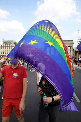 Berliner CHRISTOPHER STREET DAY 2021 - CSD - Am 24. Juli 2021 zieht der CSD in Berlin unter dem Motto SAVE OUR COMMUNITY Ð SAVE YOUR PRIDE zum 43. Mal durch die Hauptstadt. Demoteilnehmer vor dem Brandenburger Tor mit einem Mix aus Europaflagge und Regenbogenflagge. Die bunte CSD-Parade startete in diesem Jahr als Demonstration an der Leipziger Straße, führte über den Potsdamer Platz, vorbei am Denkmal für die im Nationalsozialismus verfolgten Homosexuellen zum Brandenburger Tor und über die Siegessäule zur Urania. Aufgrund der Corona-Pandemie fand die Demonstration ausschließlich unter Einhaltung der vom Berliner Senat erlassenen Vorgaben statt. Die in den Vorjahren übliche Abschlusskundgebung musste daher ausfallen.