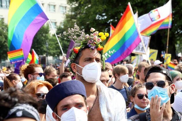 Berliner CHRISTOPHER STREET DAY 2021 - CSD - Am 24. Juli 2021 zieht der CSD in Berlin unter dem Motto SAVE OUR COMMUNITY Ð SAVE YOUR PRIDE zum 43. Mal durch die Hauptstadt. Demoteilnehmer überwiegend mit Atemschutzmasken und teils mit Regenbogenflaggen ziehen am Brandenburger Tor vorbei. Die bunte CSD-Parade startete in diesem Jahr als Demonstration an der Leipziger Straße, führte über den Potsdamer Platz, vorbei am Denkmal für die im Nationalsozialismus verfolgten Homosexuellen zum Brandenburger Tor und über die Siegessäule zur Urania. Aufgrund der Corona-Pandemie fand die Demonstration ausschließlich unter Einhaltung der vom Berliner Senat erlassenen Vorgaben statt. Die in den Vorjahren übliche Abschlusskundgebung musste daher ausfallen