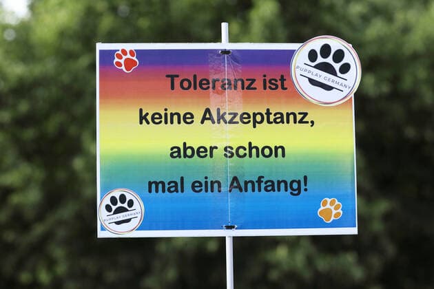 Berliner CHRISTOPHER STREET DAY 2021 - CSD - Am 24. Juli 2021 zieht der CSD in Berlin unter dem Motto SAVE OUR COMMUNITY Ð SAVE YOUR PRIDE zum 43. Mal durch die Hauptstadt. Protestschild mit der Aufschrift: Toleranz ist keine Akzeptanz, aber schon mal ein Anfang! - PUPPLAY GERMANY Die bunte CSD-Parade startete in diesem Jahr als Demonstration an der Leipziger Straße, führte über den Potsdamer Platz, vorbei am Denkmal für die im Nationalsozialismus verfolgten Homosexuellen zum Brandenburger Tor und über die Siegessäule zur Urania. Aufgrund der Corona-Pandemie fand die Demonstration ausschließlich unter Einhaltung der vom Berliner Senat erlassenen Vorgaben statt. Die in den Vorjahren übliche Abschlusskundgebung musste daher ausfallen.