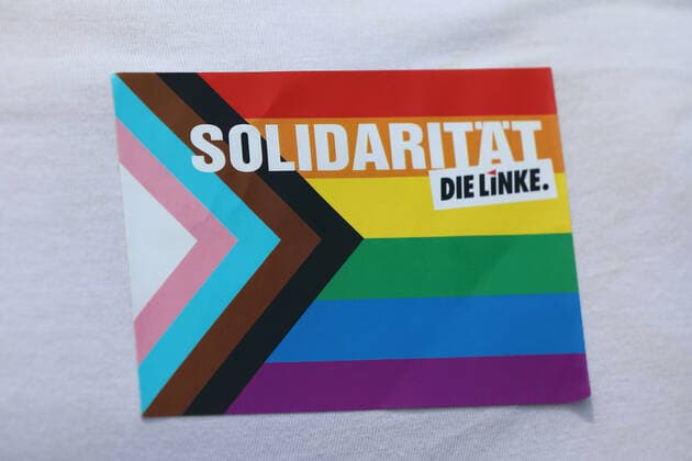 Berliner CHRISTOPHER STREET DAY 2021 - CSD - Am 24. Juli 2021 zieht der CSD in Berlin unter dem Motto SAVE OUR COMMUNITY SAVE YOUR PRIDE zum 43. Mal durch die Hauptstadt. Demoteilnehmerin trägt Aufkleber an ihrem T-Shirt dem Schriftzug: SOLIDARITÄT - DIE LINKE. Die bunte CSD-Parade startete in diesem Jahr als Demonstration an der Leipziger Straße, führte über den Potsdamer Platz, vorbei am Denkmal für die im Nationalsozialismus verfolgten Homosexuellen zum Brandenburger Tor und über die Siegessäule zur Urania. Aufgrund der Corona-Pandemie fand die Demonstration ausschließlich unter Einhaltung der vom Berliner Senat erlassenen Vorgaben statt. Die in den Vorjahren übliche Abschlusskundgebung musste daher ausfallen.