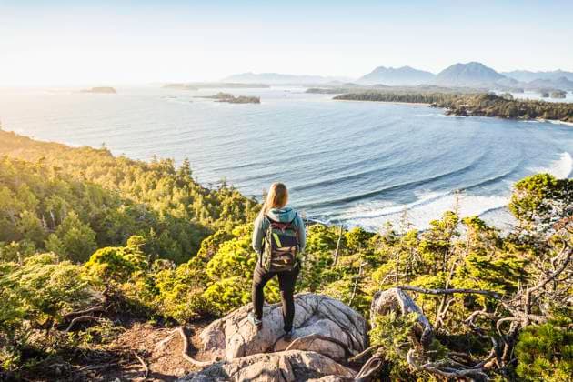 Elevated view of female hiker looking out from coastal forest, Pacific Rim National Park, Vancouver Island, British Columbia, Canada, 22.12.2016, Copyright: xManuelxSulzerx, model released, recreation,hiking,looking at view,elevated view,full length,solitude,adventure,escape,awe,fitness,tranquil,contemplation,getting away from it all,nature,backpack,mid adult woman,only one mid adult woman,hiker,one person,canada,british columbia,outdoors,coast,forest,pacific rim national park,sea,scenics,day,hooded top,jeans,travel,vacation,blue sky,active lifestyle,long beach,travel destination,only female,beauty in nature,vancouver island,tofino,looking out,January 2017 Release,Thinking,Contemplation,Looking At View,Female,Women,Mid Adult Women,Only M Ref:IS09B3TI0