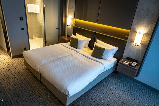 DEU, Deutschland, Berlin, 24.10.2021: Steigenberger Hotel Am Kanzleramt, Hotelzimmer. Deutsche Hospitality, vormals Steigenberger Hotel Group, im Besitz der Huazhu Group. Bett, Hotelbett, Doppelbett