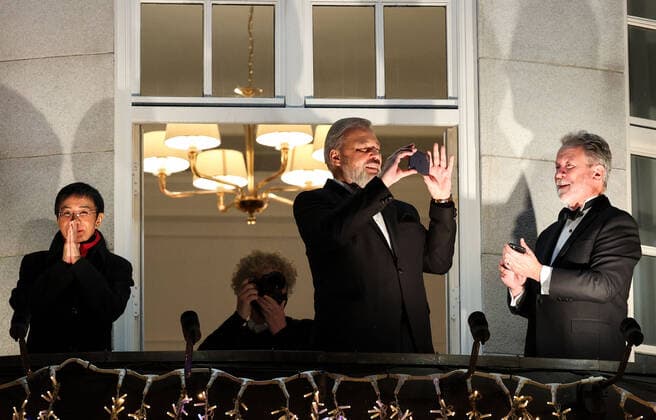 OSLO, NORWAY – DECEMBER 10, 2021: Nobel Peace Prize winners, Filipino-American journalist, co-founder and CEO of Rappler Maria Ressa, Russian journalist, Novaya Gazeta editor-in-chief Dmitry Muratov, and World Food Programme Executive Director David Beasley (L-R) greet the participants in a torchlight parade in honour of the Nobel Peace Prize winners from a balcony of the Grand Hotel. The Norwegian Nobel Committee has decided to award the Nobel Peace Prize for 2021 to Filipino-American journalist, co-founder and CEO of Rappler Maria Ressa and Russian journalist, Novaya Gazeta editor-in-chief Dmitry Muratov in recognition of their efforts to safeguard freedom of expression, which is a precondition for democracy and lasting peace . The World TS11B68C