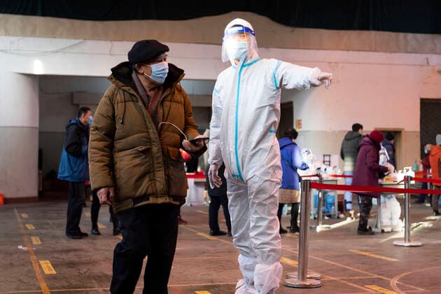 (211212) -- HARBIN, Dec. 12, 2021 -- Guan Chao guides a citizen to take a nucleic acid test at a testing site in Harbin, capital of northeast China s Heilongjiang Province, Dec. 11, 2021. Clad in protective gear, Guan Chao started his volunteer work with his mother Wang Tao as usual. Guan, 27, is a dance teacher. Due to the latest resurgence of COVID-19 cases in Harbin, his offline teaching routine has been disrupted. Guan joined the fight against the epidemic. He became a volunteer for the citywide nucleic acid testing, medical supplies delivery and regular disinfection on public spaces. Seeing medical staff, community workers and volunteers work day and night, Guan s mother Wang Tao also joined the efforts. Wearing a red voluntee