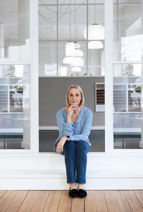Smiling businesswoman with hand on chin at office doorway model released property released, FKF04604