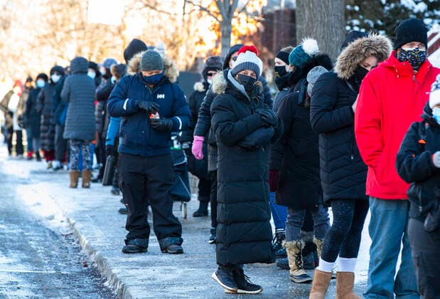 (220104) -- TORONTO, Jan. 4, 2022 -- People wearing face masks line up outside a COVID-19 vaccination clinic in Toronto, Canada, Jan. 3, 2022. Canada reported 35,618 new COVID-19 cases Monday, raising its national total to 2,302,695 with 30,393 deaths, according to local media CTV. (Photo by Xinhua) CANADA-TORONTO-COVID-19-CASES ZouxZheng