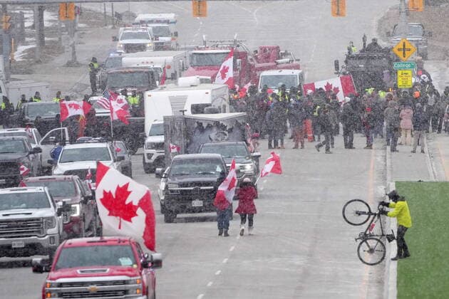 February 12, 2022, Windsor, ON, CANADA: Protesters face police officers as they enforce an injunction against their demonstration, which has blocked traffic across the Ambassador Bridge by protesters against COVID-19 restrictions, in Windsor, Ont., Saturday, Feb. 12, 2022. Windsor CANADA - ZUMAc35_ 20220212_zaf_c35_125 Copyright: xNathanxDenettex