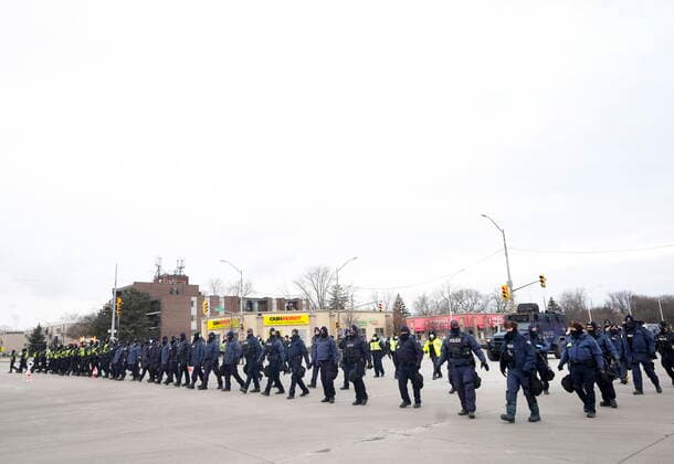 February 13, 2022, WINDSOR, ON, CANADA: Police walk the line to remove all truckers and supporters after a court injunction gave police the power to enforce the law after protesters blocked the access leading from the Ambassador Bridge, linking Detroit and Windsor, as truckers and their supporters continue to protest against COVID-19 vaccine mandates and restrictions, in Windsor, Ont., Sunday, Feb. 13, 2022. WINDSOR CANADA - ZUMAc35_ 20220213_zaf_c35_038 Copyright: xNathanxDenettex