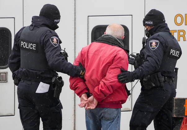 February 13, 2022, WINDSOR, ON, CANADA: A protester is arrested by as police remove truckers and supporters after a court injunction gave police the power to enforce the law after blocking the access leading from the Ambassador Bridge, linking Detroit and Windsor, as truckers and their supporters continue to protest against the COVID-19 vaccine mandates and restrictions in Windsor, Ont., on Sunday, February 13, 2022. WINDSOR CANADA - ZUMAc35_ 20220213_zaf_c35_061 Copyright: xNathanxDenettex