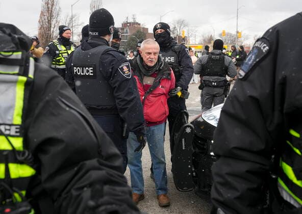 February 13, 2022, WINDSOR, ON, CANADA: A protester is arrested by as police remove truckers and supporters after a court injunction gave police the power to enforce the law after blocking the access leading from the Ambassador Bridge, linking Detroit and Windsor, as truckers and their supporters continue to protest against the COVID-19 vaccine mandates and restrictions in Windsor, Ont., on Sunday, February 13, 2022. WINDSOR CANADA - ZUMAc35_ 20220213_zaf_c35_065 Copyright: xNathanxDenettex