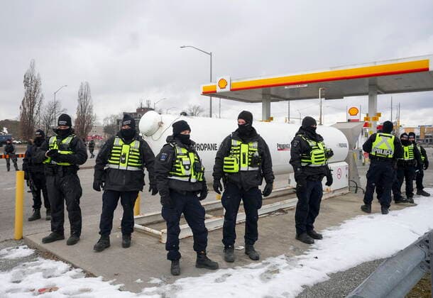 February 13, 2022, WINDSOR, ON, CANADA: Police officers guard a gas station and propane tank as they remove truckers and supporters after a court injunction gave police the power to enforce the law after blocking the access leading from the Ambassador Bridge, linking Detroit and Windsor, as truckers and their supporters continue to protest against the COVID-19 vaccine mandates and restrictions in Windsor, Ont., on Sunday, February 13, 2022. WINDSOR CANADA - ZUMAc35_ 20220213_zaf_c35_067 Copyright: xNathanxDenettex