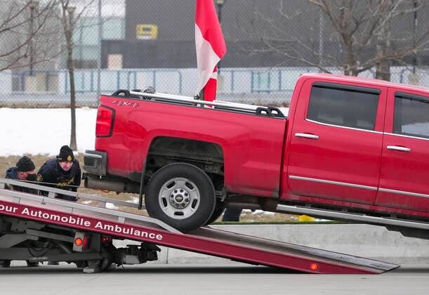 February 13, 2022, WINDSOR, ON, CANADA: Police tow a truck as they remove all truckers and supporters after a court injunction gave police the power to enforce the law after protesters blocked the access leading from the Ambassador Bridge, linking Detroit and Windsor, as truckers and their supporters continue to protest against COVID-19 vaccine mandates and restrictions, in Windsor, Ont., Sunday, Feb. 13, 2022. WINDSOR CANADA - ZUMAc35_ 20220213_zaf_c35_042 Copyright: xNathanxDenettex