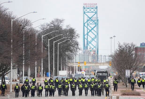 February 13, 2022, WINDSOR, ON, CANADA: Police walk the line to remove all truckers and supporters after a court injunction gave police the power to enforce the law after protesters blocked the access leading from the Ambassador Bridge, linking Detroit and Windsor, as truckers and their supporters continue to protest against COVID-19 vaccine mandates and restrictions, in Windsor, Ont., Sunday, Feb. 13, 2022. WINDSOR CANADA - ZUMAc35_ 20220213_zaf_c35_034 Copyright: xNathanxDenettex