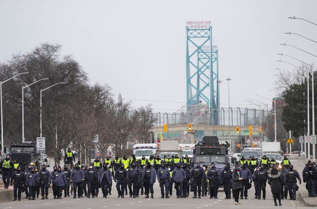February 13, 2022, Windsor, Ontario, Canada: Police walk the line to remove all truckers and supporters after a court injunction gave police the power to enforce the law after protesters blocked the access leading from the Ambassador Bridge, linking Detroit and Windsor, as truckers and their supporters continue to protest against COVID-19 vaccine mandates and restrictions, in Windsor, Ont., Sunday, Feb. 13, 2022. Windsor Canada - ZUMAc35_ 20220213_zaf_c35_037 Copyright: xNathanxDenettex