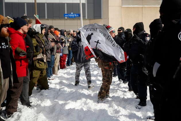Kanada, Protest gegen Corona-Maßnahmen in Ottawa - Polizei beginnt mit Räumung von LKW-Blockade February 18, 2022, OTTAWA, ON, CANADA: A protester confronts a line of police officers, as authorities move to end a protest against COVID-19 measures that has grown into a broader anti-government protest and occupation, in Ottawa, Friday, Feb. 18, 2022. OTTAWA CANADA - ZUMAc35_ 20220218_zaf_c35_138 Copyright: xColexBurstonx