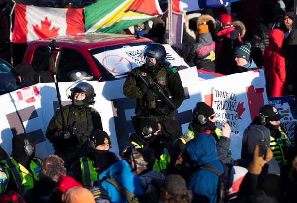 February 18, 2022, Ottawa, ON, CAN: A Surete du Quebec police officer holds a crowd control weapon while another records video on a monopod, as police form a line at an enclosure on Rideau Street as they work to end an ongoing protest against COVID-19 measures that has grown into a broader anti-government protest, on its 22nd day, in Ottawa, on Friday, Feb. 18, 2022. Ottawa CAN - ZUMAc35_ 20220218_zaf_c35_248 Copyright: xJustinxTangx