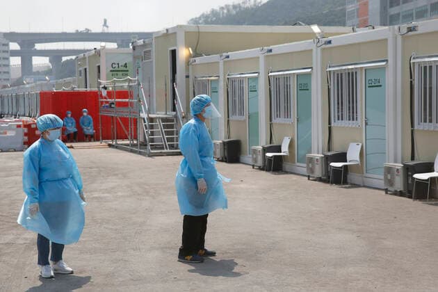 (220302) -- HONG KONG, March 2, 2022 -- Staff members work at the community isolation facility (CIF) in Tsing Yi, south China s Hong Kong, March 2, 2022. A newly built CIF started admitting its first batch of COVID-19 patients in Hong Kong on Tuesday evening. The facility, located in Tsing Yi, is open for service one day after its construction was completed within just one week on Monday with the support of the mainland. The CIF, with the capacity of accommodating about 3,900 patients, is a combination of modular cubicles, with each room equipped with basic furniture and bedding, air conditioner, smoke detector, and fire extinguisher. ) CHINA-HONG KONG-ISOLATION FACILITY (CN) WanxHoude