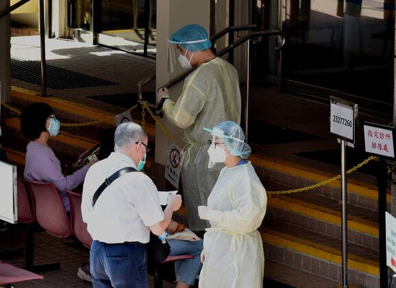 (220314) -- HONG KONG, March 14, 2022 -- Medical workers guide citizens at a designated clinic in Hong Kong, south China, March 14, 2022. On Monday, Hong Kong registered 12,040 new COVID-19 cases by nucleic acid tests, and 14,868 additional positive cases through self-reported rapid antigen tests, official data showed. ) CHINA-HONG KONG-COVID-19-CASES (CN) LoxPingxFai