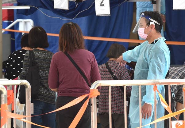 (220314) -- HONG KONG, March 14, 2022 -- A medical worker guides citizens at a mobile nucleic acid testing site in Hong Kong, south China, March 14, 2022. On Monday, Hong Kong registered 12,040 new COVID-19 cases by nucleic acid tests, and 14,868 additional positive cases through self-reported rapid antigen tests, official data showed. ) CHINA-HONG KONG-COVID-19-CASES (CN) LoxPingxFai