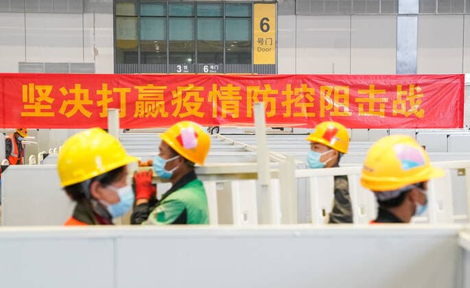 (220408) -- SHANGHAI, April 8, 2022 -- Workers work at the construction site of a temporary hospital at the National Exhibition and Convention Center (Shanghai) in east China s Shanghai, April 8, 2022. Shanghai has opened and will continue to construct more temporary hospitals to enhance the city s treatment capacity for COVID-19 infections in its latest COVID-19 resurgence, authorities said Friday. Four municipal-level temporary hospitals, three located in Pudong District and one in Chongming District, have been put into use as of Friday. Covering a total of 500,000 square meters, the four sites can offer a total of 38,000 beds, said Jin Chen, deputy director of Shanghai s housing and urban-rural development management committee.