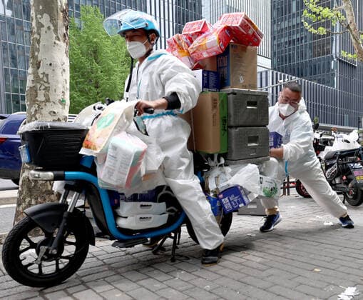 (220415) -- SHANGHAI, April 15, 2022 -- Du Shun (R), deputy manager of a Hema Fresh store in Wuhan, helps Liu Zengyu, a delivery man from Jiangxi Province, start his electric bicycle to deliver goods in Shanghai, east China, April 15, 2022. Recently, Hema Fresh, a Chinese fresh items supermarket, has organized aid teams from more than 20 cities including Beijing, Chengdu, Xi an, Hefei and Wuhan to support Shanghai in the delivery of living supplies. Du Shun, deputy manager of a Hema Fresh store in Wuhan, central China s Hubei Province, led a team to assist in the supply guarantee work in a Hema Fresh store in Shanghai from April 12. Du said that in 2020 he once witnessed the great contribution made by the Shanghai medical team to the e