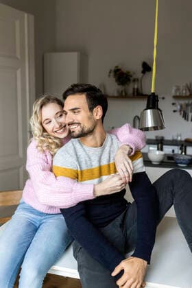 Smiling girlfriend embracing boyfriend at home model released, Symbolfoto property released, PESF03574