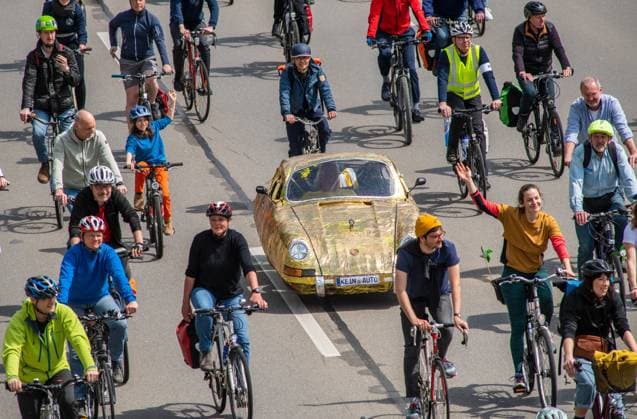 Rad-Sternfahrt des ADFC, Teilstück über die Autobahn A96, München, 23. April 2023 Deutschland, München, 23. April 2023, große Rad-Sternfahrt des ADFC, hier auf der gesperrten Autobahn A 96 bei München-Laim, Teilnehmer mit goldenem Tretauto und Nummernschild Kein Auto, , Fahrraddemo für die Unterstützung des Volksbegehrens Radentscheid Bayern , Motto der Fahrrad-Demo: gemeinsam Radeln für eine bayernweit bessere Radinfrastruktur, Teilstück über die A96 von Sendling bis zur Ausfahrt Blumenau, Verkehr, Fahrrad fahren, Verkehrswende, Umwelt, Klimaschutz, Bayern,