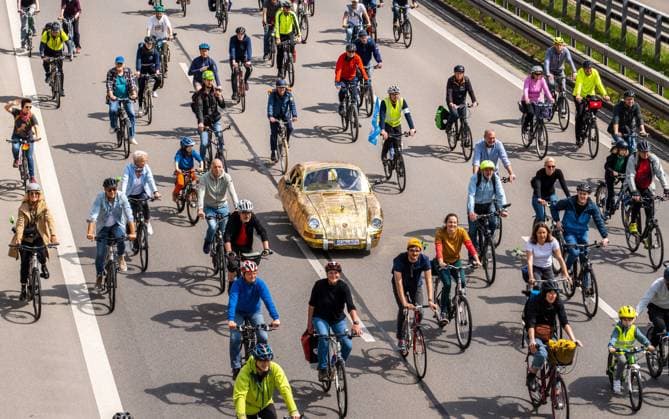 Rad-Sternfahrt des ADFC, Teilstück über die Autobahn A96, München, 23. April 2023 Deutschland, München, 23. April 2023, große Rad-Sternfahrt des ADFC, hier auf der gesperrten Autobahn A 96 bei München-Laim, Teilnehmer mit goldenem Tretauto und Nummernschild Kein Auto, , Fahrraddemo für die Unterstützung des Volksbegehrens Radentscheid Bayern , Motto der Fahrrad-Demo: gemeinsam Radeln für eine bayernweit bessere Radinfrastruktur, Teilstück über die A96 von Sendling bis zur Ausfahrt Blumenau, Verkehr, Fahrrad fahren, Verkehrswende, Umwelt, Klimaschutz, Bayern,