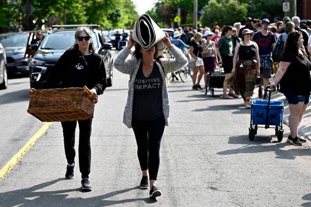 May 27, 2023, Ottawa, ON, CAN: Bargain hunters carry items as they walk along the road during the Great Glebe Garage Sale, in Ottawa, on Saturday, May 27, 2023. The community event draws thousands of people to the Glebe, one of OttawaöÄÃ s heritage neighbourhoods, with vendors donating a percentage proceeds to the Ottawa Food Bank. Ottawa CAN - ZUMAc35_ 20230527_zaf_c35_018 Copyright: xJustinxTangx