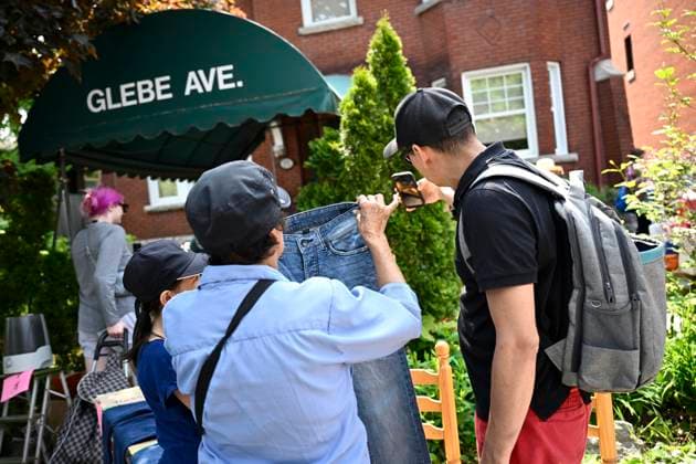 May 27, 2023, Ottawa, ON, CAN: Bargain hunters hold up a pair of jeans to a person on the other end of a video call during the Great Glebe Garage Sale, in Ottawa, on Saturday, May 27, 2023. The community event draws thousands of people to the Glebe, one of OttawaöÄÃ s heritage neighbourhoods, with vendors donating a percentage proceeds to the Ottawa Food Bank. Ottawa CAN - ZUMAc35_ 20230527_zaf_c35_023 Copyright: xJustinxTangx