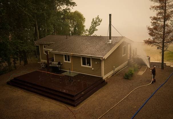 August 20, 2023, SCOTCH CREEK, BC, CANADA: Trevor Manzuik, who was evacuated from his home due to the Lower East Adams Lake wildfire, sprays down his property after returning home by boat, in Scotch Creek, B.C., on Sunday, August 20, 2023. SCOTCH CREEK CANADA - ZUMAc35_ 20230820_zaf_c35_120 Copyright: xDarrylxDyckx