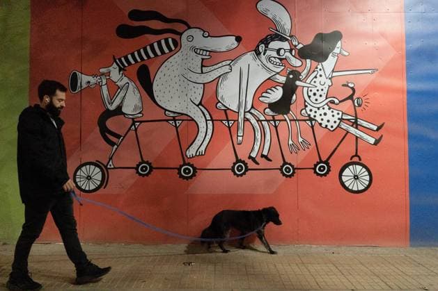 April 14, 2024, Santiago, Metropolitana, Chile: A man and his dog walk in front of a mural by artist Alberto Montt in Santiago, Chile. Santiago Chile - ZUMAb332 20240414_zip_b332_008 Copyright: xMatiasxBasualdox