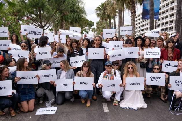 Cannes - Guerrieres De La Paix Flash Mob Action for Gaza and Israel Women from ?Women warriors of peace? carrying messages in French, Arabic, Hebrew and English stating ?Peace?, ?Cease Fire?, Release the Hostages?, demonstrate on the ?Croisette? in Cannes, to draw attention to the situation in Gaza and Israel, around the 77th Cannes Film Festival, in Cannes, France, on May 20, 2024. Photo by Ammar Abd Rabbo ABACAPRESS.COM Cannes France Copyright: xABACAx