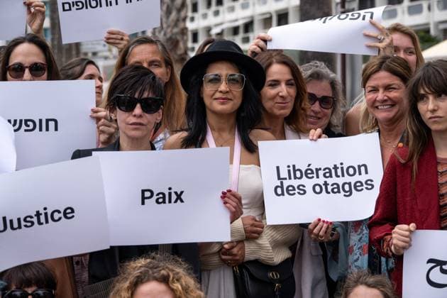 Cannes - Guerrieres De La Paix Flash Mob Action for Gaza and Israel Moroccan Belgian actress Loubna Azabal (first from L) and producer Lamia Chraibi (2nd from L) and other women from ?Women warriors of peace? carry messages in French, Arabic, Hebrew and English stating ?Peace?, ?Cease Fire?, Release the Hostages?, demonstrate on the ?Croisette? in Cannes, to draw attention to the situation in Gaza and Israel, around the 77th Cannes Film Festival, in Cannes, France, on May 20, 2024. Photo by Ammar Abd Rabbo ABACAPRESS.COM Cannes France Copyright: xABACAx