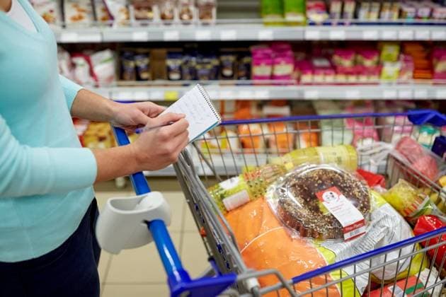 consumerism and people concept - woman with notebook and shopping cart or trolley buying food at grocery store or supermarket. woman with food in shopping cart at supermarket ,model released, Symbolfoto; Konsumismus und Personen Konzept Frau mit Notizbuch und Einkaufen Karren Oder Rollwagen kaufend Lebensmittel im grocery Ladengeschaeft Oder Supermarkt Frau mit Lebensmittel in Einkaufen Karren im Supermarkt ,model released, Symbolfoto ING_33594_207047