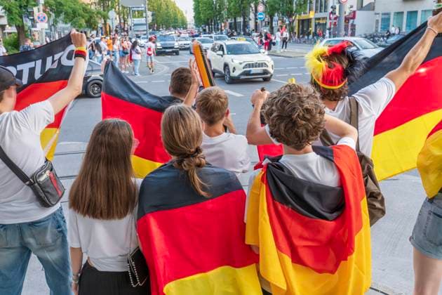 Junge Fußballfans feiern den deutschen Sieg im Spiel gegen Ungarn, schwenken Deutschlandfahnen an der Leopoldstraße, Fußball-EM, München, 19. Juni 2024 Deutschland, München, 19. Juni 2024, Fußballfans feiern den deutschen Sieg im Spiel gegen Ungarn, schwenken Deutschlandfahnen un der Leopoldstraße, Sommermärchen, Deutschland gegen Ungarn endete 2:0, Fußball-EM, UEFA EURO 2024, Fußball-Europameisterschaft, Fußball, Sport,