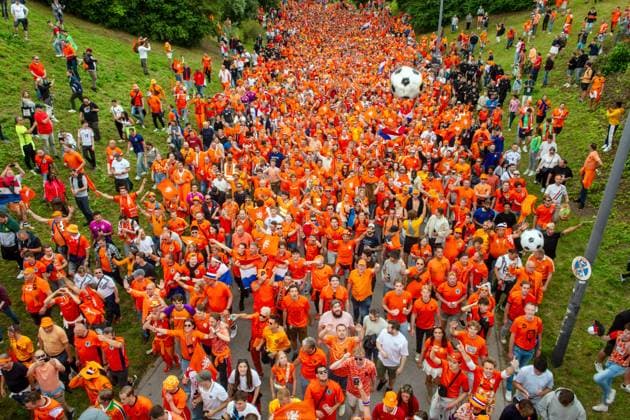Tausende fröhliche Oranje Fans ziehen durch den Olympiapark zur Fan Zone, Fan-Walk, UEFA EURO 2024, München, 2. Juli 2024 Deutschland, München, 2. Juli 2024, Fan-Marsch der niederländischen Fußballfans zum Olympiapark, tausende fröhliche Oranje Fans treffen sich schon mittags und ziehen mit DJ und Musik zur Fan Zone, hier Szene am Spiridon-Louis-Ring, feiern dann gemeinsam mit rumänischen Anhängern eine riesige Party, vor dem Spiel Niederlande-Rumänien um 18 Uhr, UEFA EURO 2024, Fußball-Europameisterschaft, Fußball, Sport,