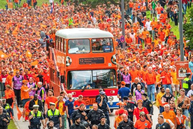 Tausende fröhliche Oranje Fans ziehen durch den Olympiapark zur Fan Zone, Fan-Walk, UEFA EURO 2024, München, 2. Juli 2024 Deutschland, München, 2. Juli 2024, Fan-Marsch der niederländischen Fußballfans zum Olympiapark, tausende fröhliche Oranje Fans treffen sich schon mittags und ziehen mit DJ und Musik zur Fan Zone, hier Szene am Spiridon-Louis-Ring, ein Fan-Bus fährt mit, vor dem Spiel Niederlande-Rumänien um 18 Uhr, UEFA EURO 2024, Fußball-Europameisterschaft, Fußball, Sport,