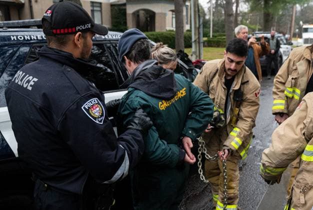 November 21, 2024, Ottawa, On, Canada: Greenpeace climate activist Keith Stewart, centre, has chains removed by the Ottawa Fire Service after being arrested by police officers for taking part in a sit-in styled protest calling for greater climate change awareness by Conservative Leader Pierre Poilievre, outside of Stornoway, the official residence of the country s official opposition, in Ottawa, on Thursday, Nov. 21, 2024. Ottawa Canada - ZUMAc35_ 20241121_zaf_c35_008 Copyright: xSpencerxColbyx